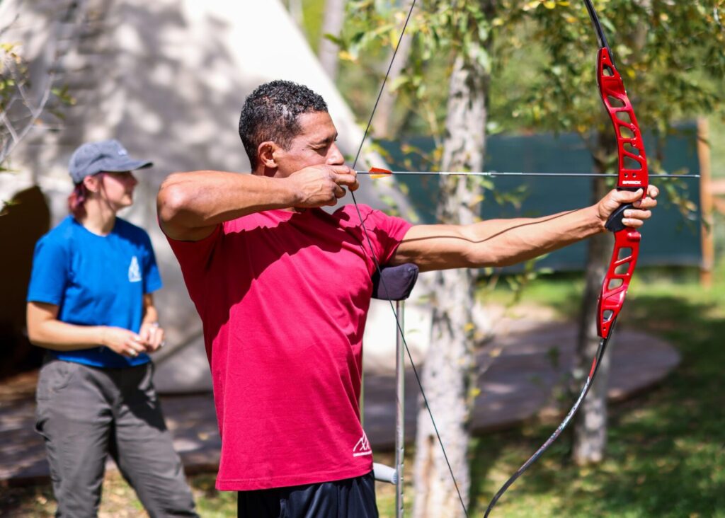 Anthony Robles, with help from Izzy DeGreen at back, takes part in an archery session organized by Challenge Aspen on Friday, Sept. 20, 2024, at a private residence near Basalt. Robles, who was born with one leg, is a former national champion wrestler at Arizona State and is the inspiration behind a new film, “Unstoppable,” that was shown at Aspen Film’s 45th annual Filmfest on Friday night. Austin Colbert/The Aspen Times